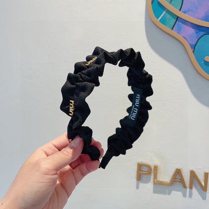 HAIRBAND IN BLACK WRINKLED NYLON GOLD LOGO 415930