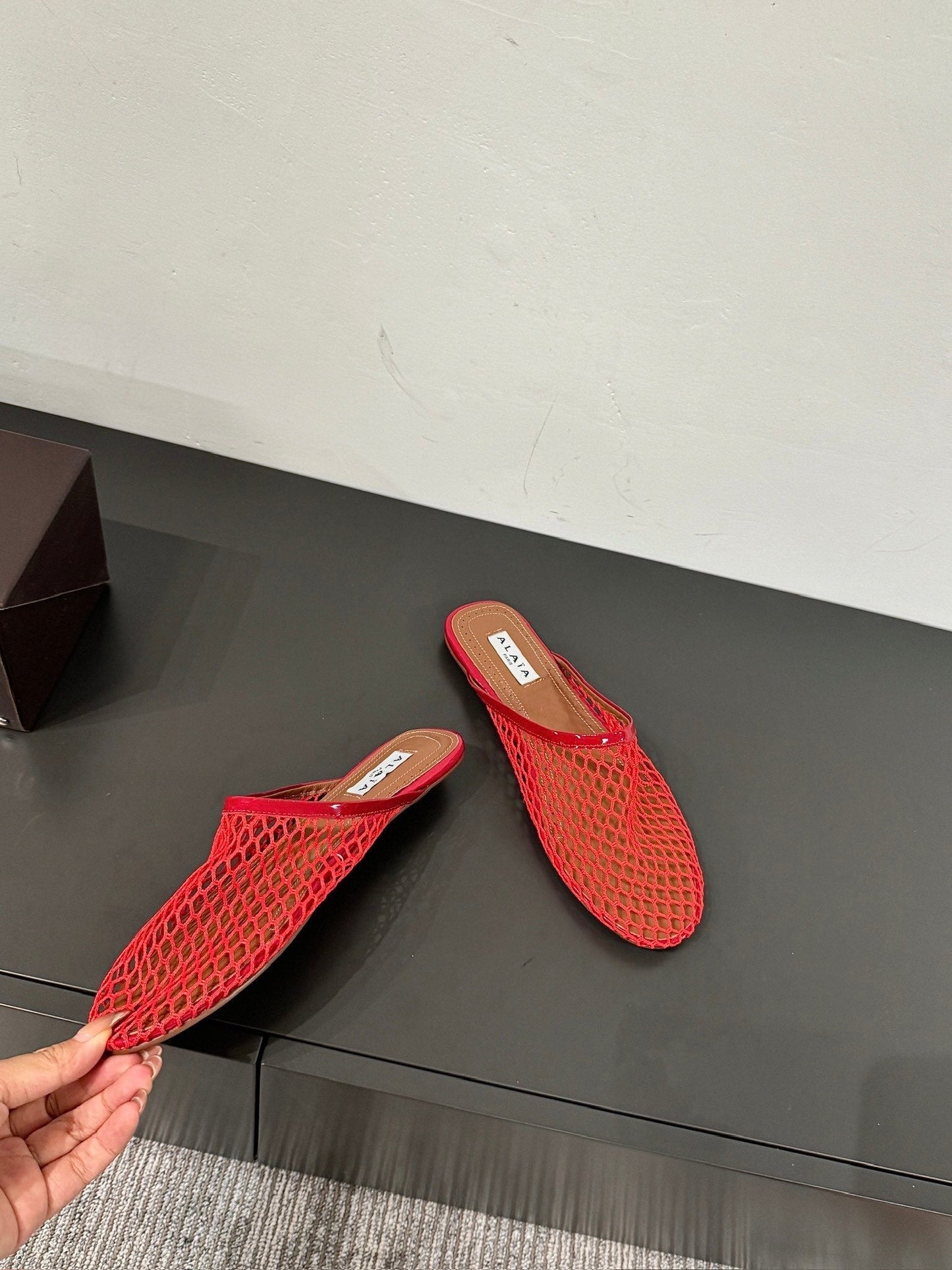 ALAIA FLAT MULES IN CHERRY RED MESH FISHNET
