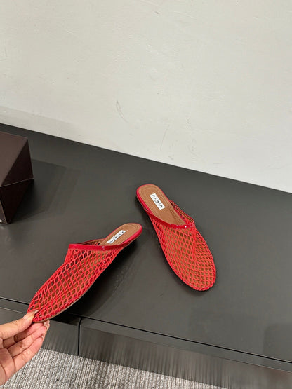 ALAIA FLAT MULES IN CHERRY RED MESH FISHNET