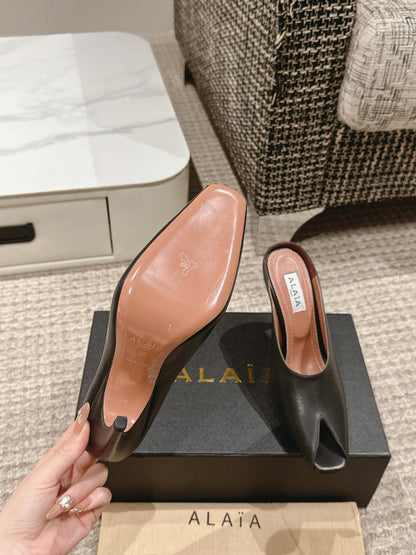 ALAIA SPIKE JEWEL MULES IN BLACK CALFSKIN