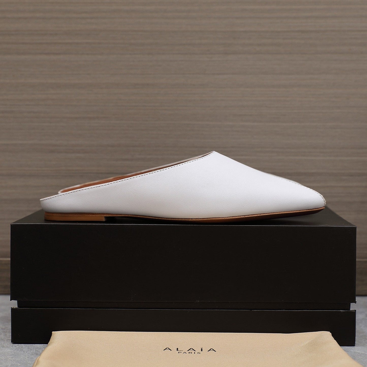 ALAIA FLAT MULE IN WHITE LAMBSKIN