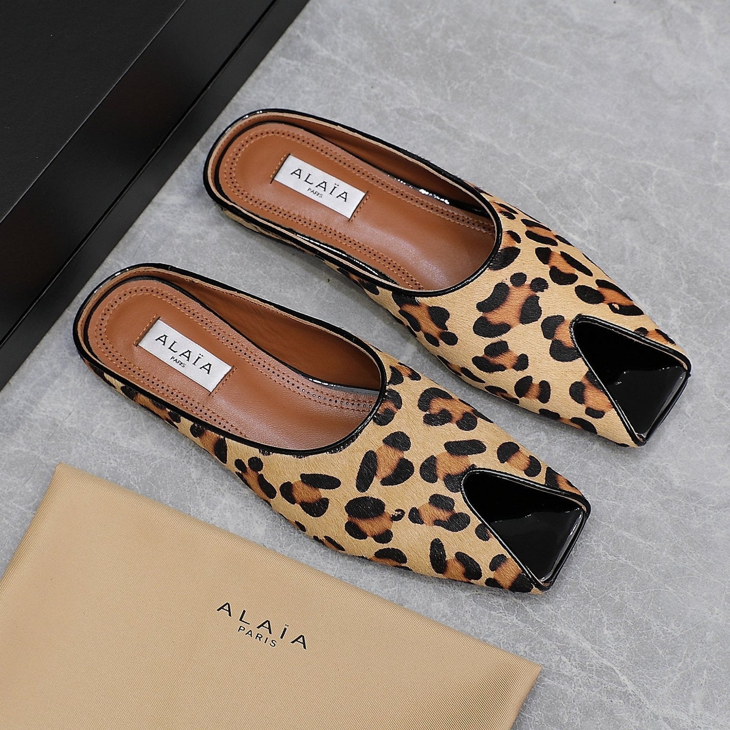 ALAIA FLAT MULE IN LEOPARD LAMBSKIN