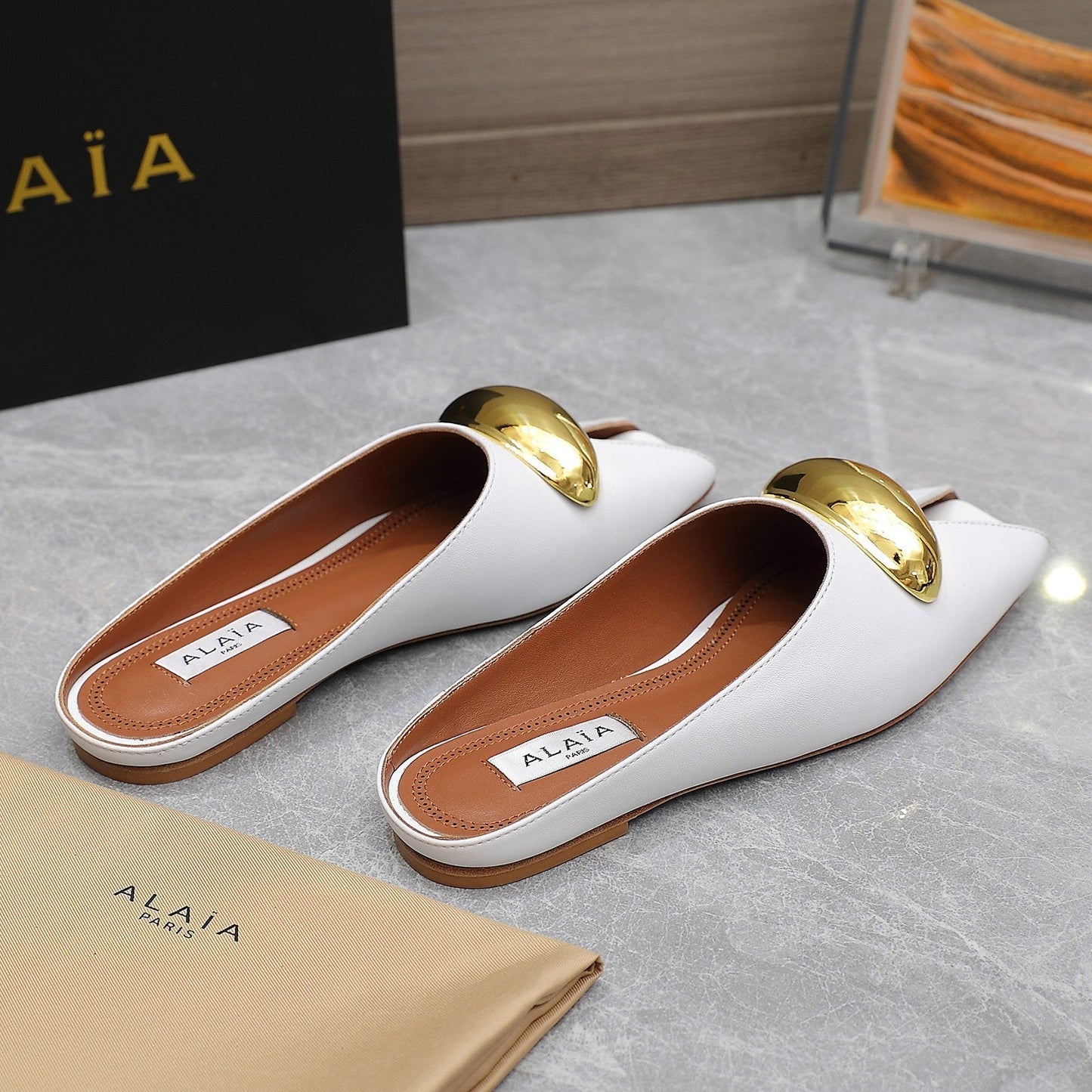 ALAIA FLAT MULE IN WHITE LAMBSKIN WITH GOLD HARDWARE