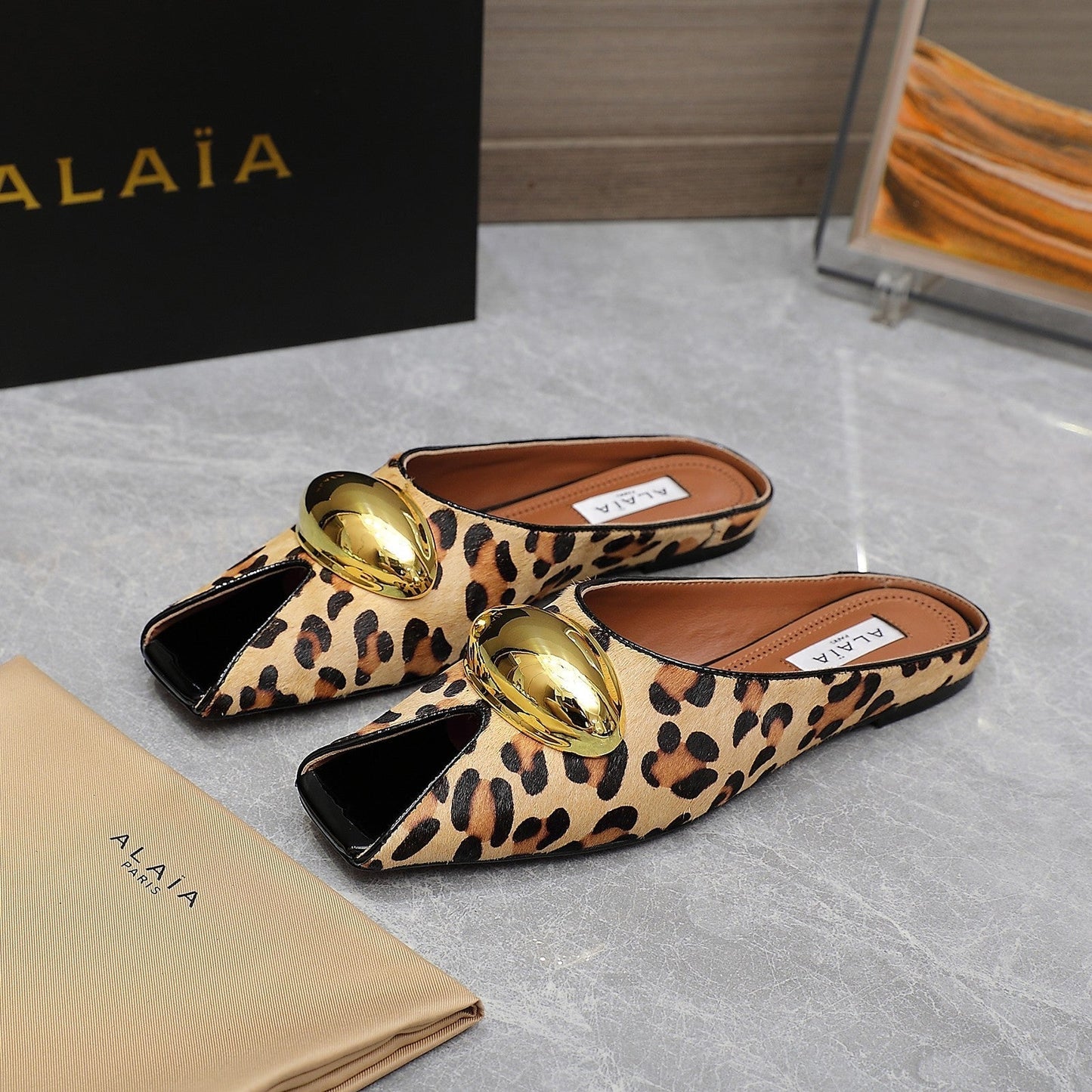 ALAIA FLAT MULE IN LEOPARD LAMBSKIN WITH GOLD HARDWARE