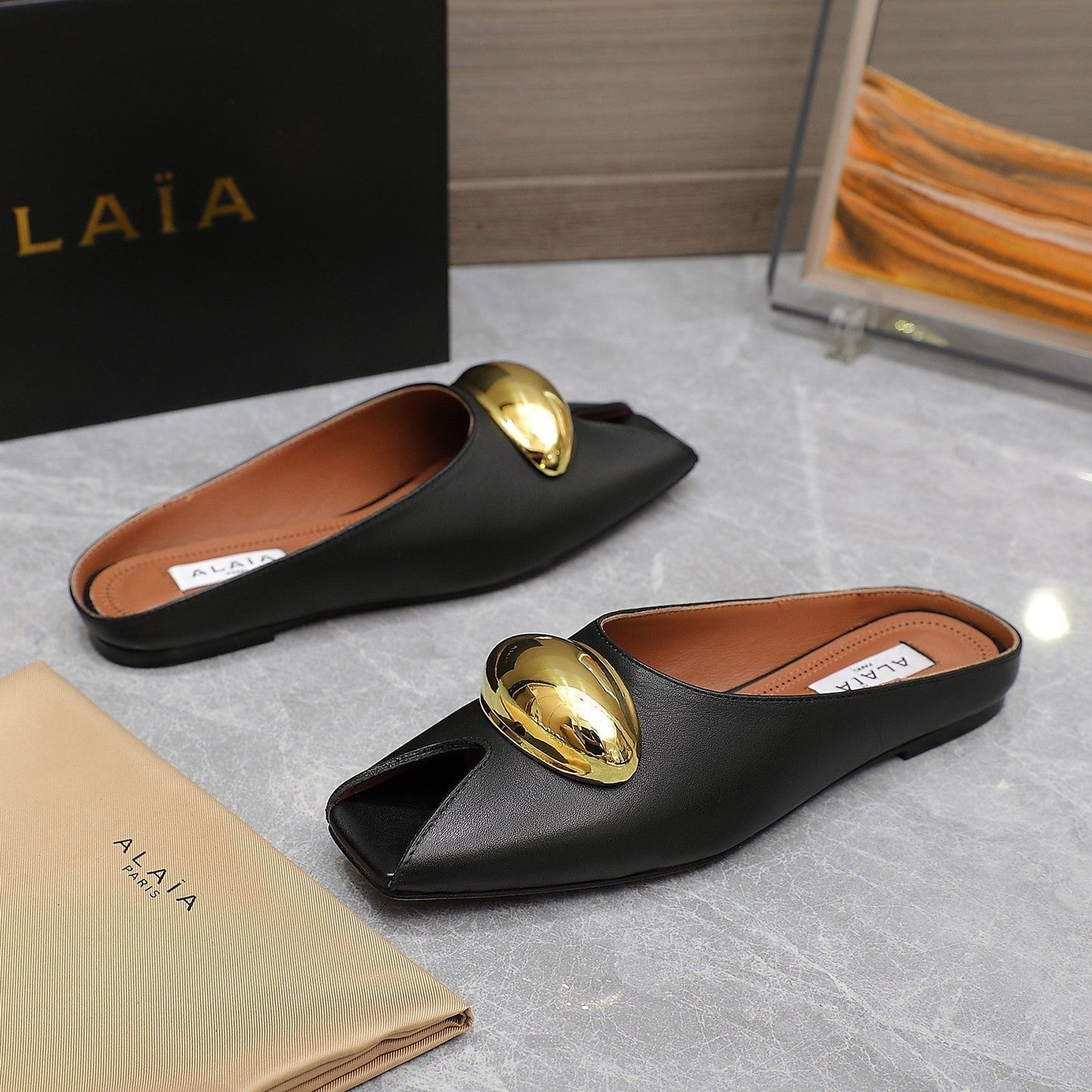 ALAIA FLAT MULE IN BLACK LAMBSKIN WITH GOLD HARDWARE