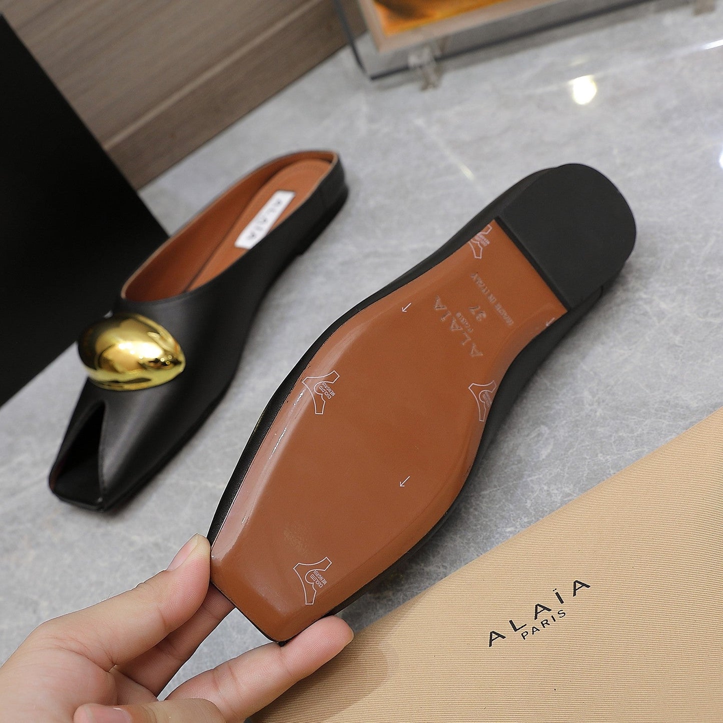 ALAIA FLAT MULE IN BLACK LAMBSKIN WITH GOLD HARDWARE
